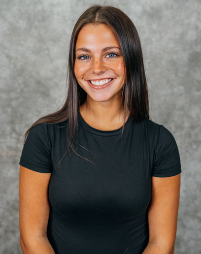 Portrait of a smiling young woman. She is wearing a black t-shirt.